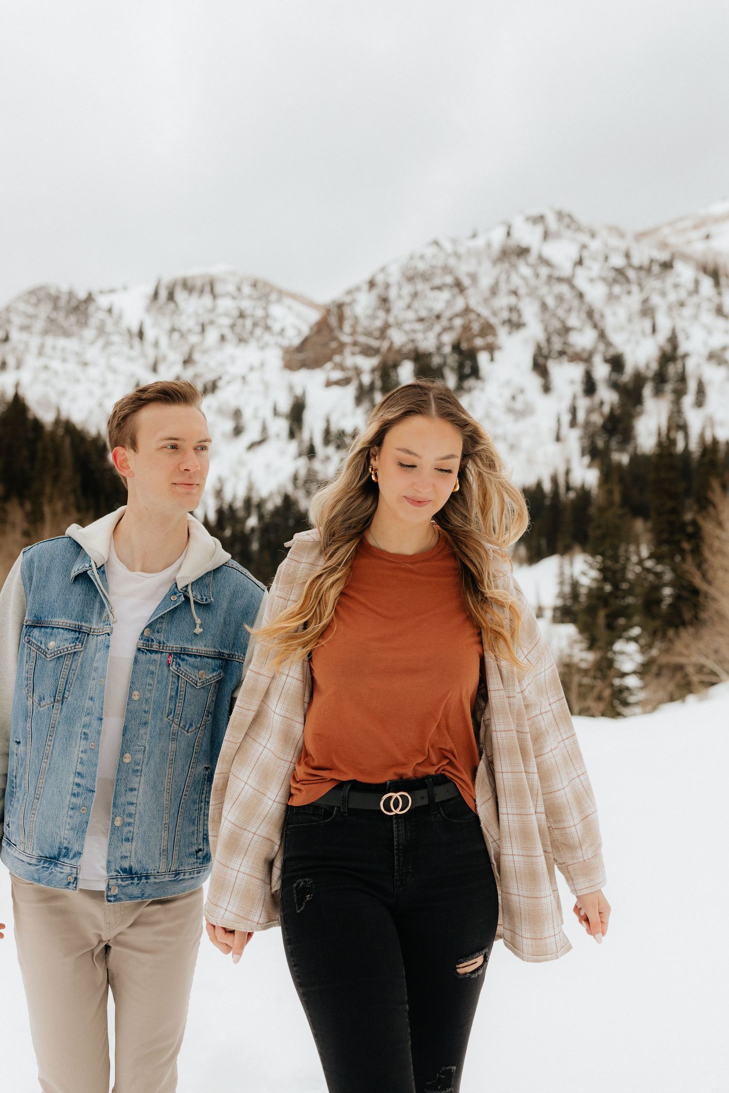 Couple walking together, holding hands in winter mountains