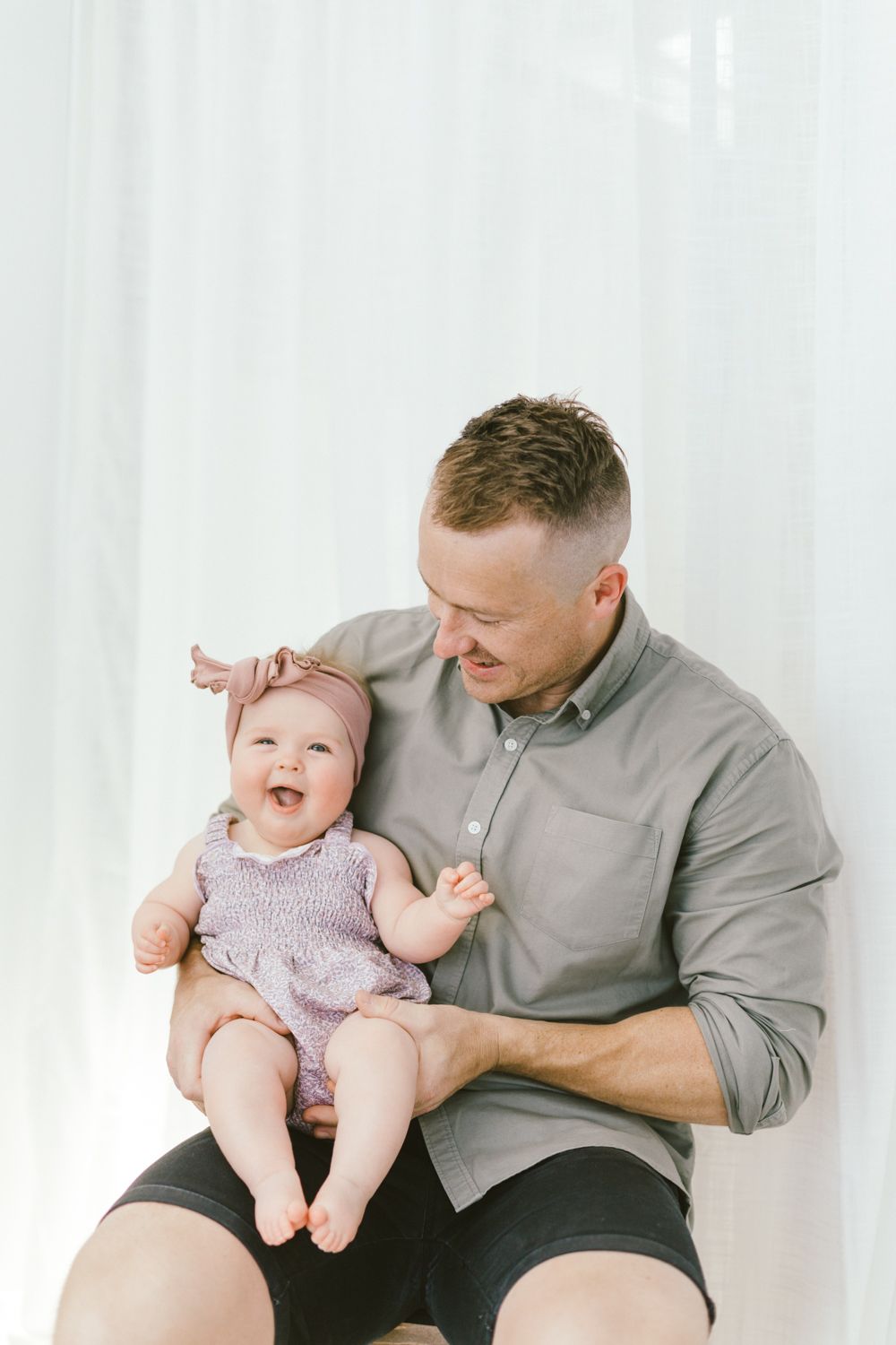 Candid portrait showing joyful expressions against white backdrop.