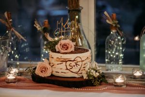 Rustic birch bark wedding cake with pink roses and personalized S+K carved heart topper.