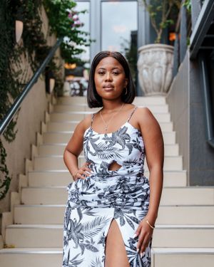Tropical print maxi dress with front cutout detail photographed on outdoor staircase.