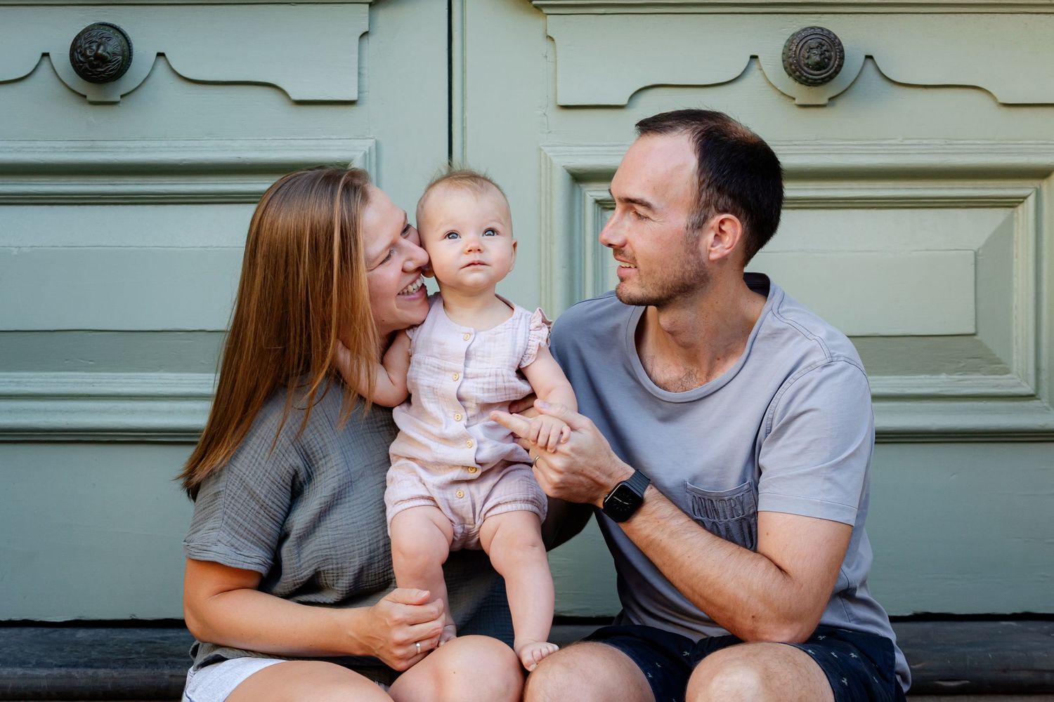 A loving family moment captured against a vintage door backdrop.