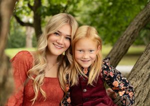 sisters smile together for closeup outdoor portrait