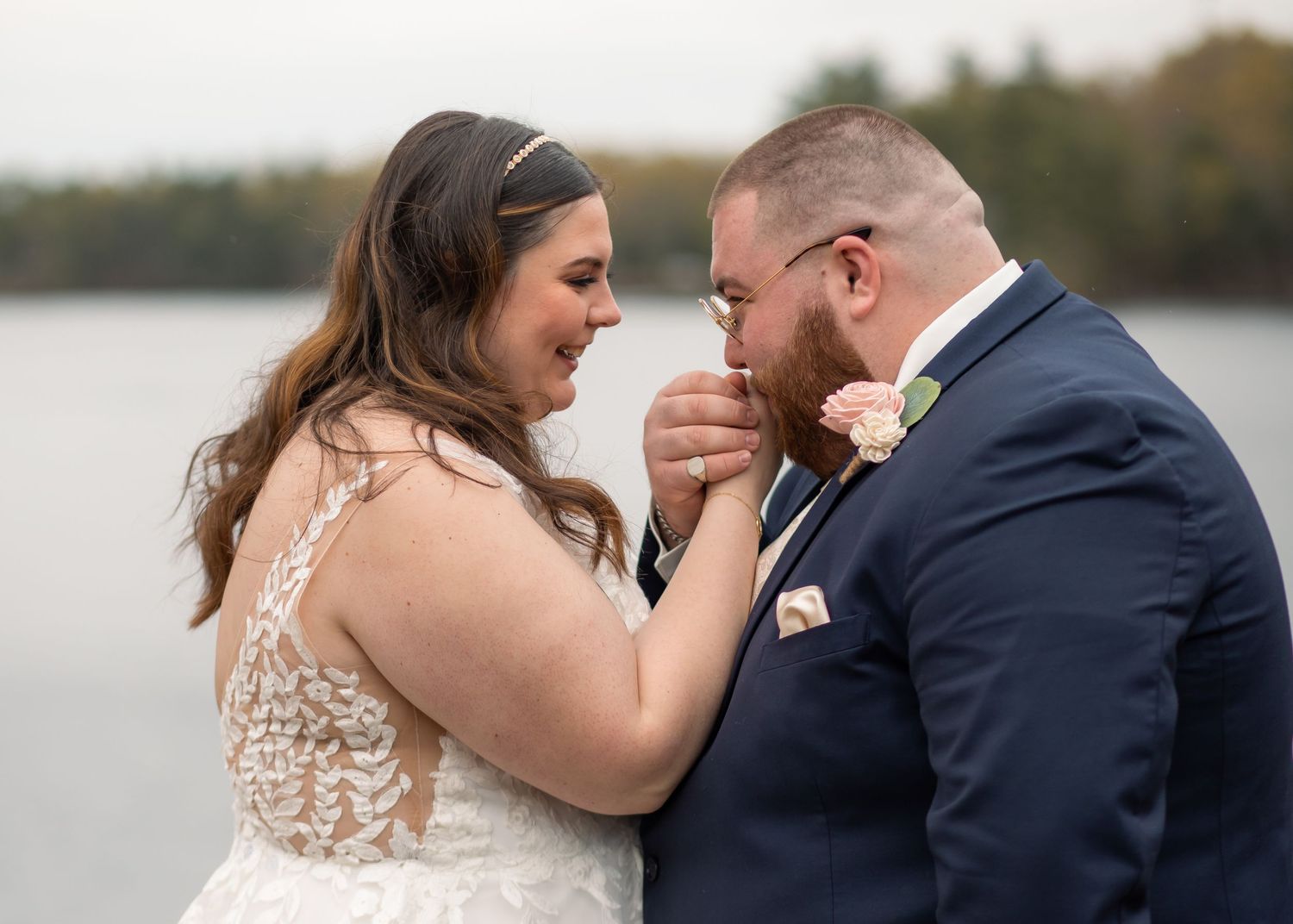 A romantic wedding couple shares an intimate moment together by a lakeside during their autumn celebration in Chepachet, Rhode Island.