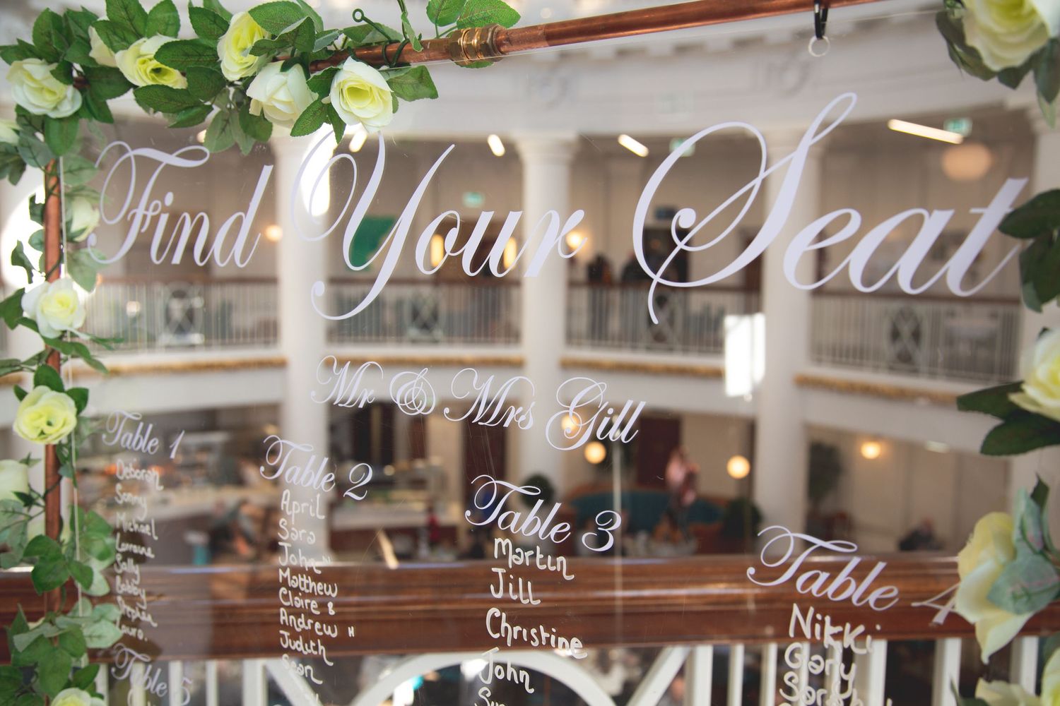 Decorative seating chart display with vine decorations and elegant lettering.