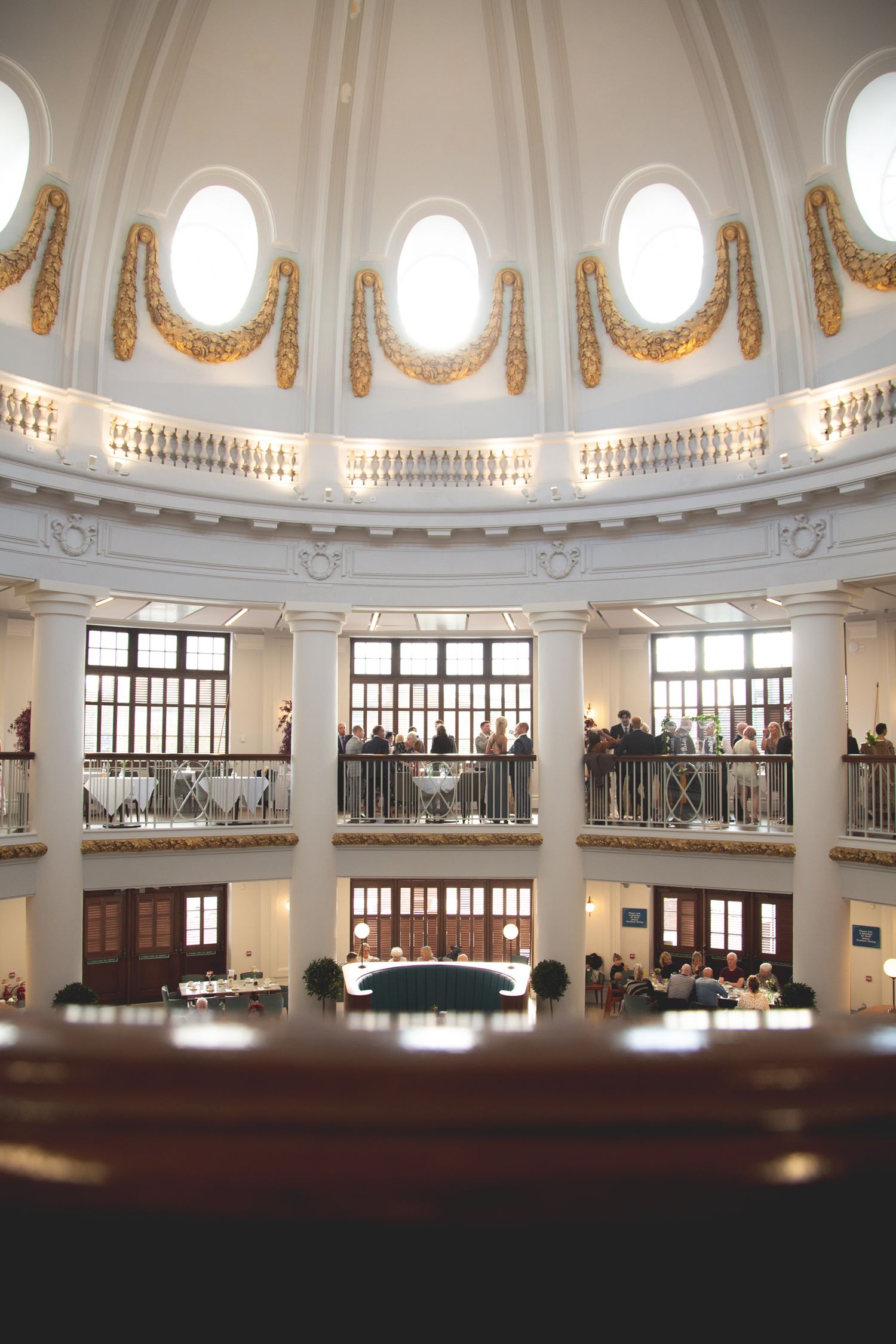 Grand domed interior of historic rotunda with ornate architectural details and circular balcony.