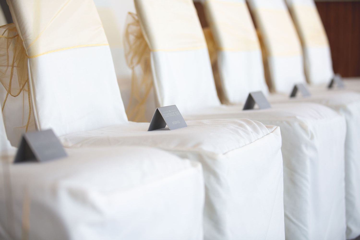 Row of pristine white hotel pillows arranged neatly against a headboard.