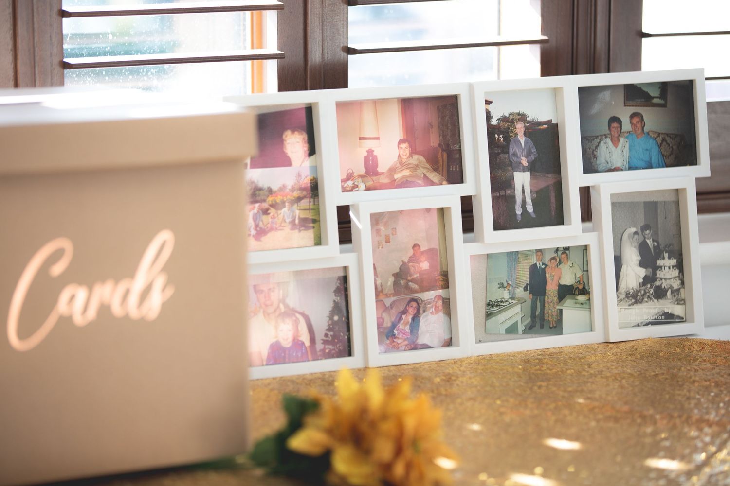 Display of vintage-style photos next to a card box with yellow floral decorations.