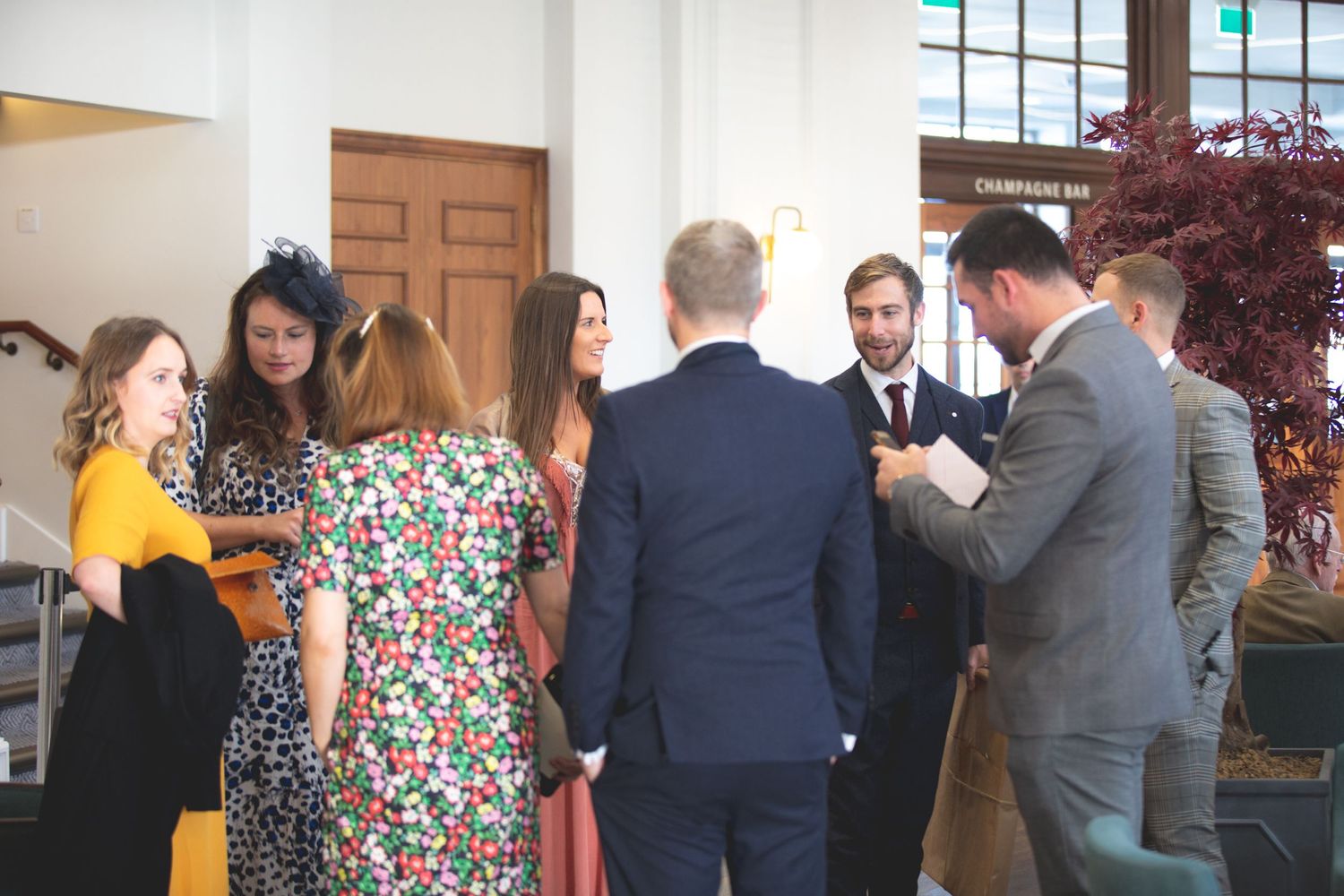 Guests engaged in lively conversation at an indoor reception.