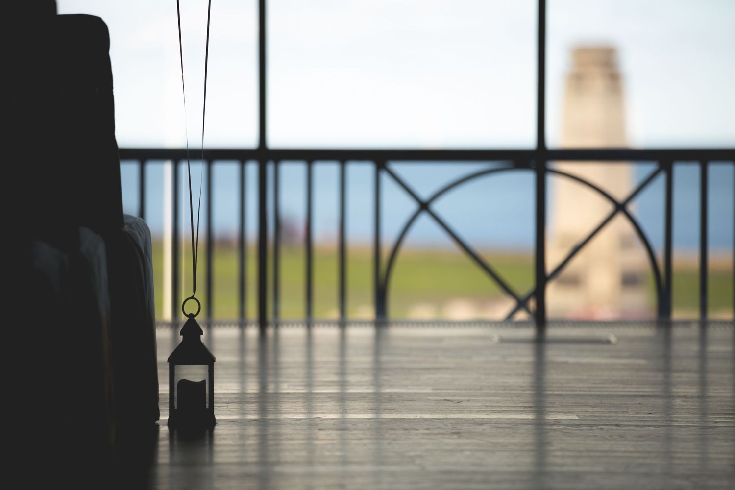 Minimalist balcony railing silhouetted against a hazy landscape view.