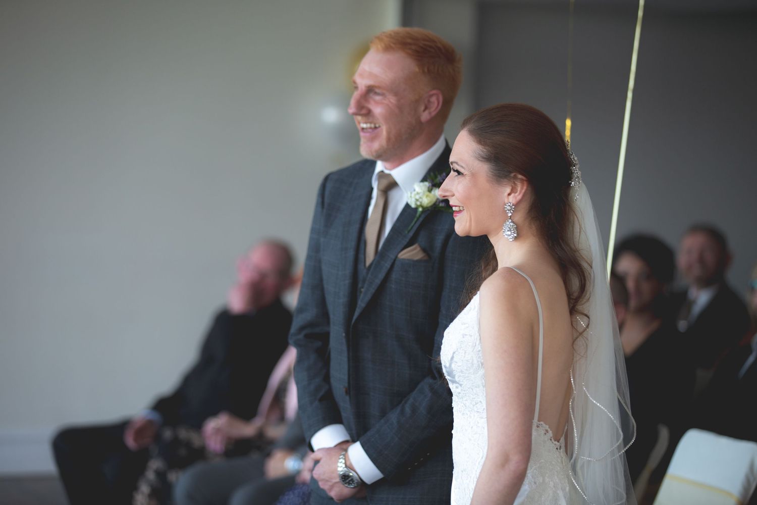 A couple shares a happy moment during their indoor wedding ceremony.