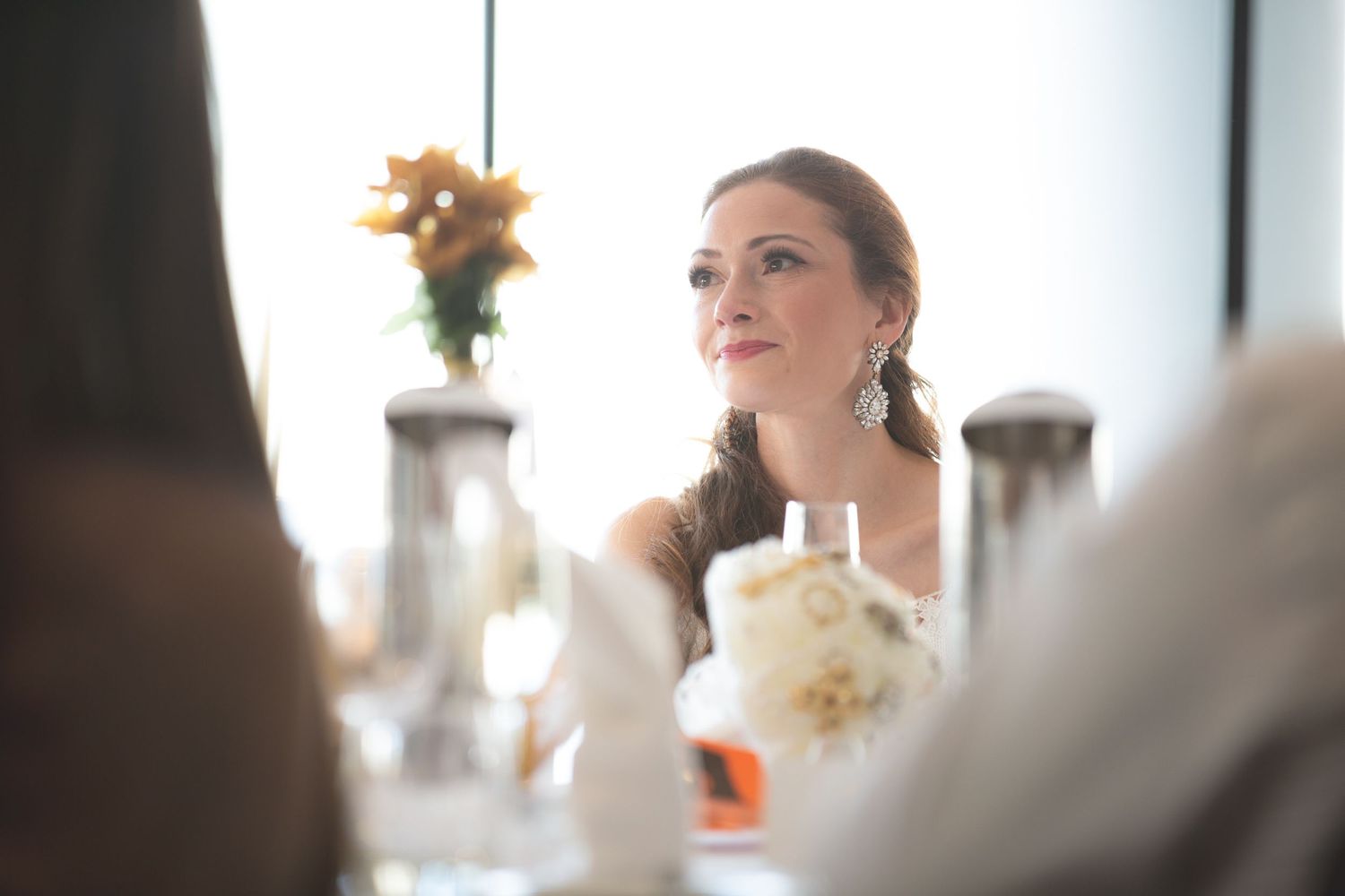 Elegant wedding reception table setting with white floral centerpiece.