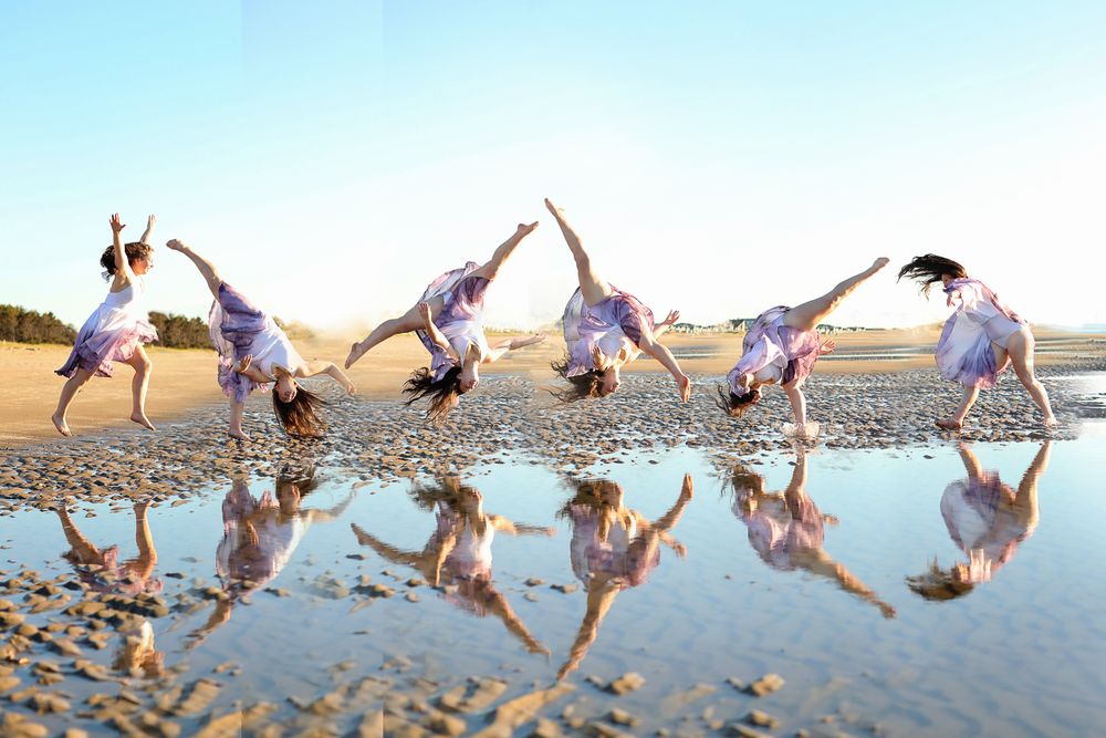 Senior portrait of a girl flipping in the sand by the ocean in Ogunquit beach maine