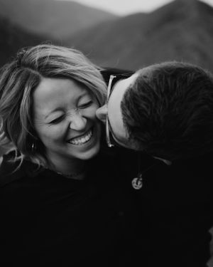 An intimate black and white portrait of a laughing couple sharing a close moment.