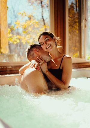Romantic couple sharing intimate moment together in luxurious spa hot tub.