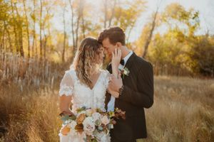 Romantic sunset wedding portrait in golden autumn field.