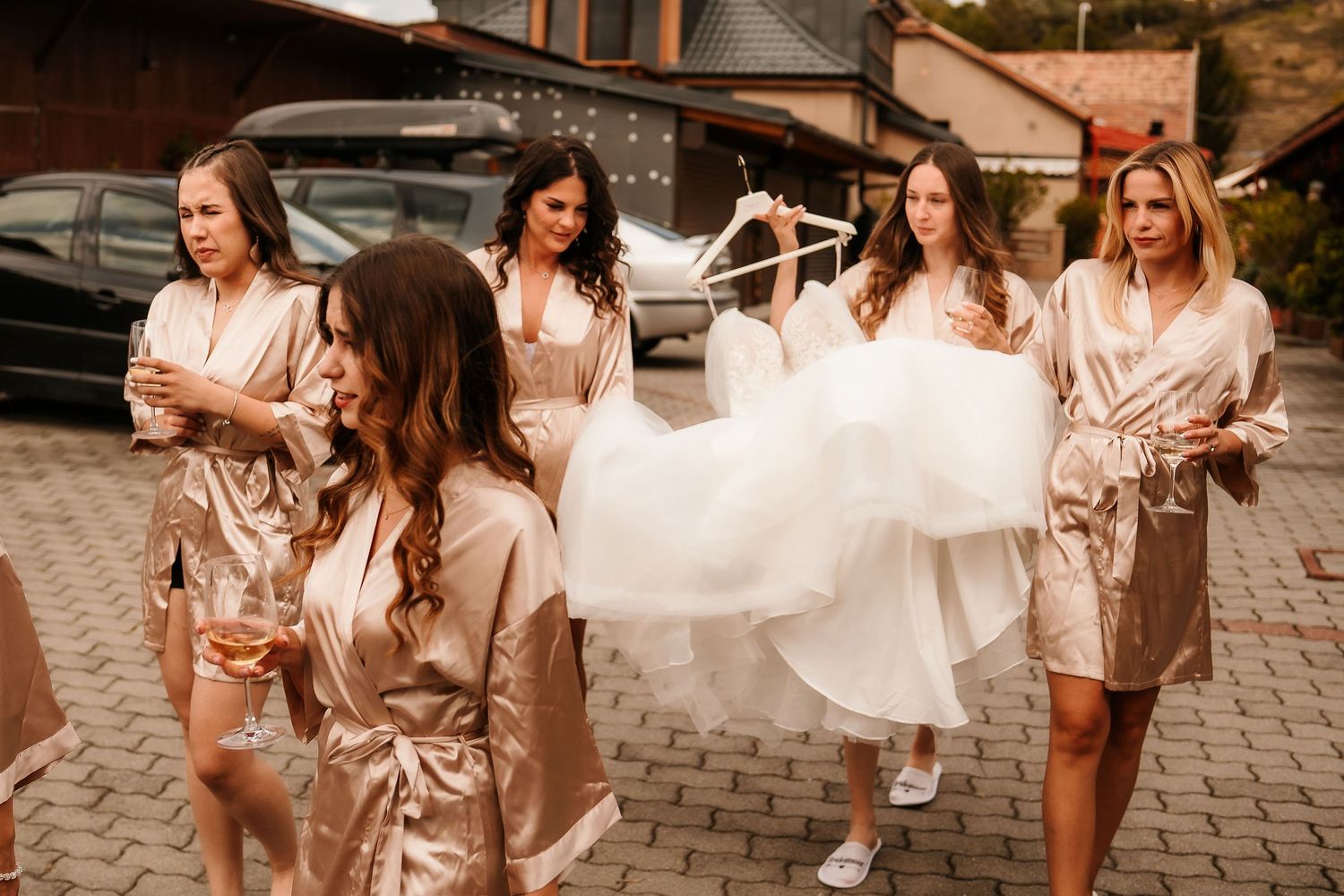 Celebratory group walking together in matching silk robes with flowing white dress.