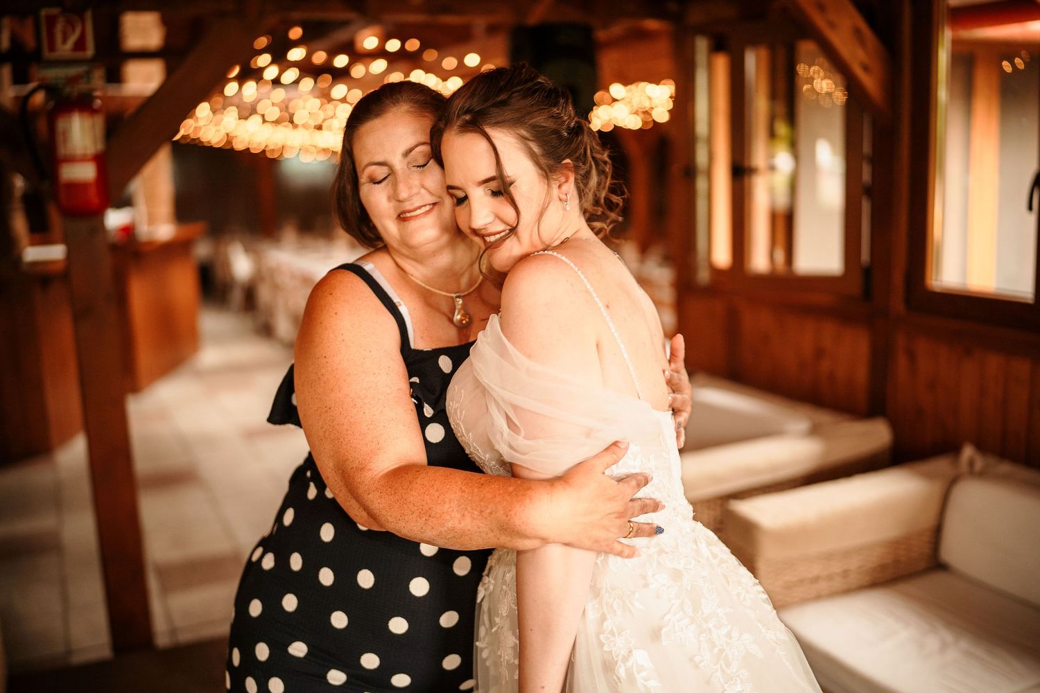 Emotional embrace captured in warm lighting with polka dot and formal attire.