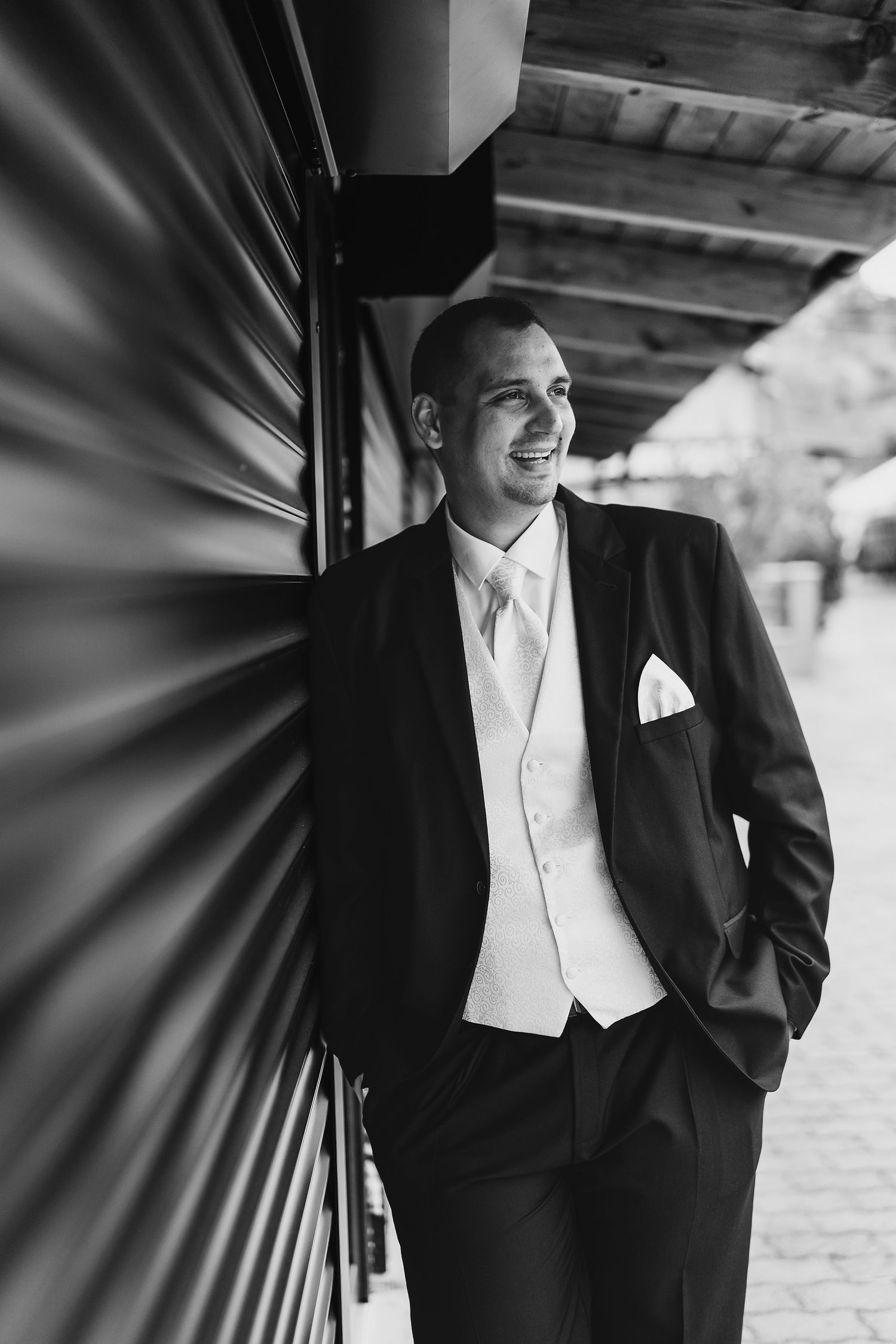 Black and white portrait showcasing elegant wedding attire against a modern architectural backdrop.