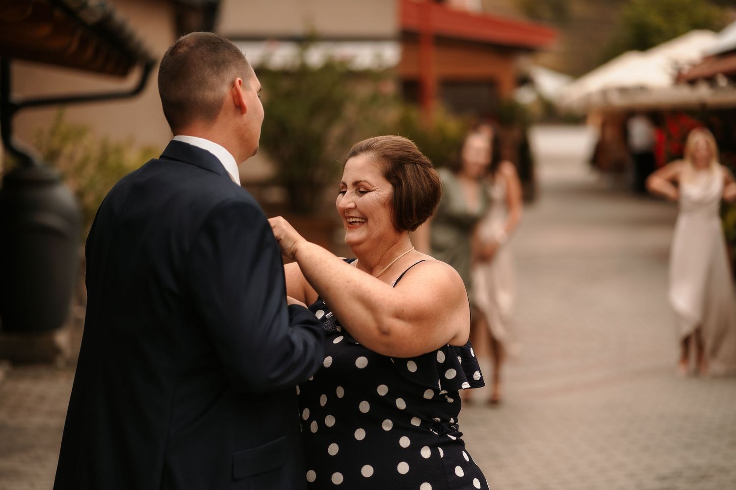 A joyful dance moment captured between two people at an outdoor wedding celebration.