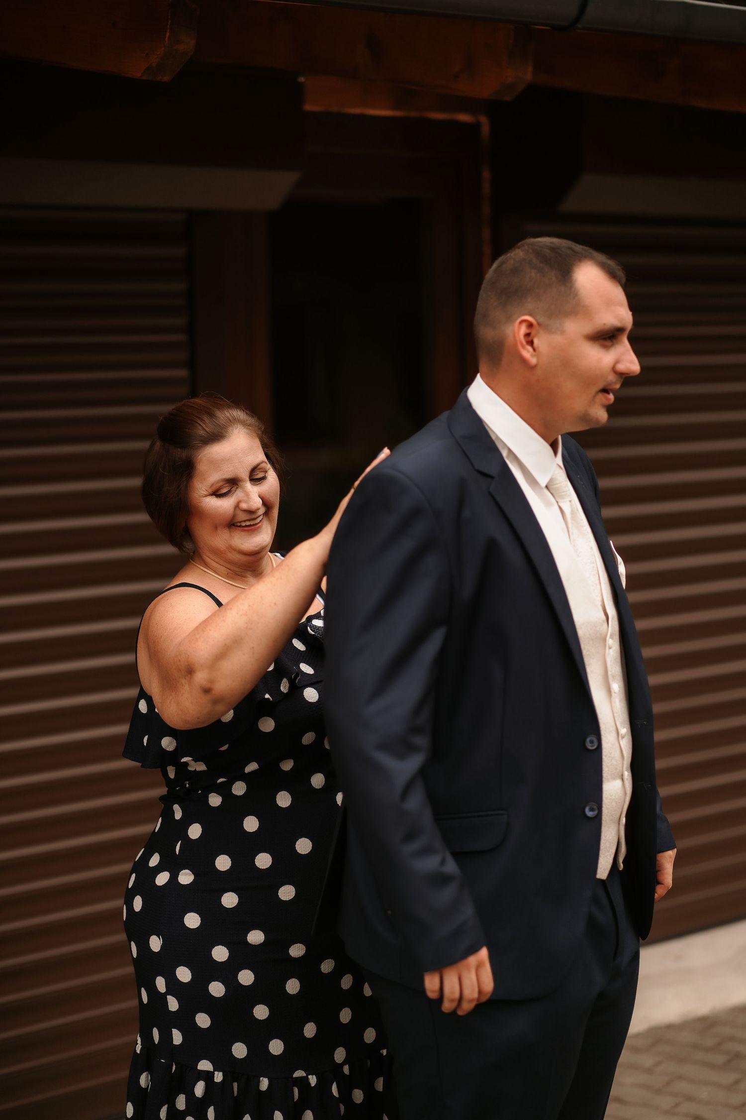 Two people share a candid moment during a wedding dance outdoors.