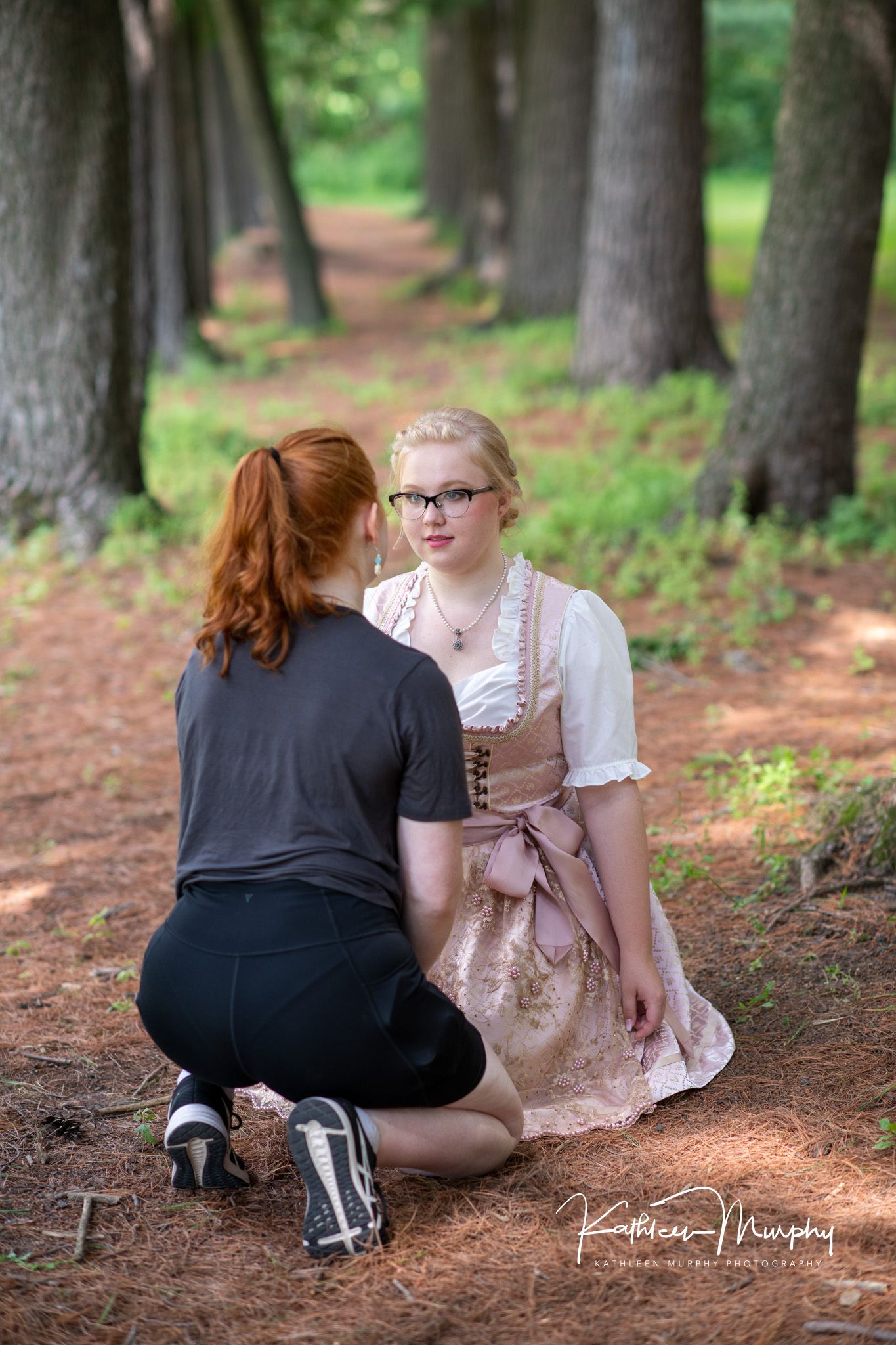 Two sisters talk in a forest of pines