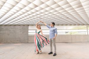 Couple dancing under geometric patterned ceiling in modern architectural space.