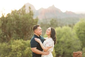 A joyful embrace captured against a backdrop of desert mountains at sunset.