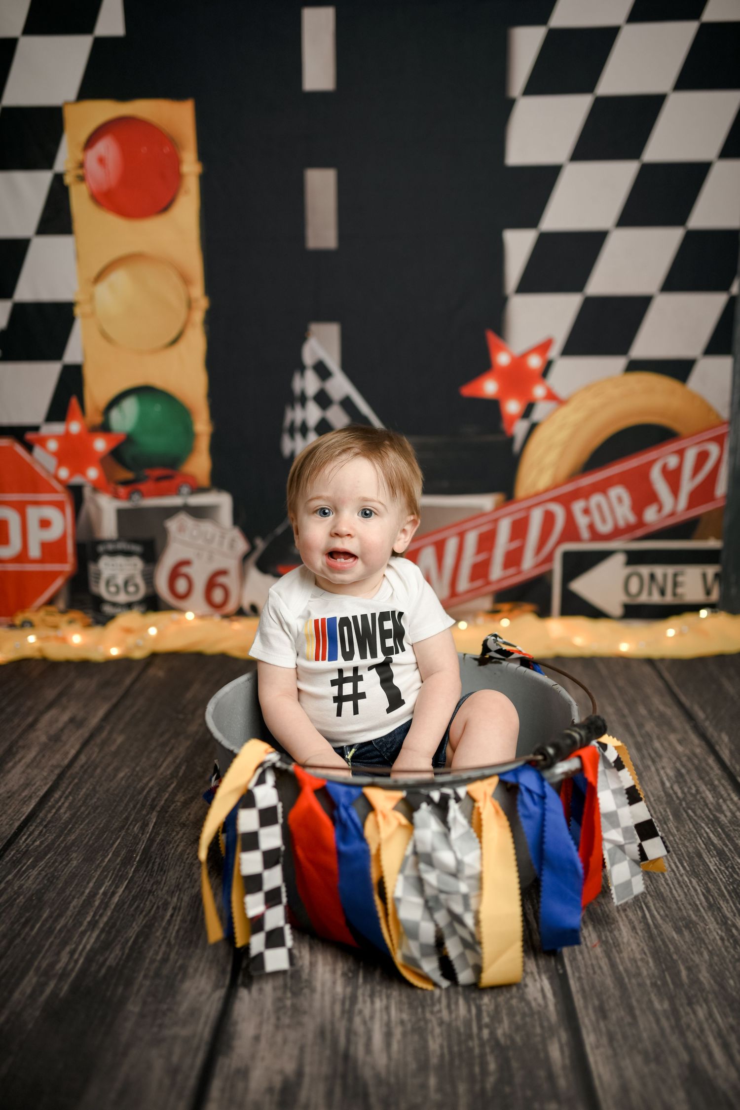 Racing themed photoshoot with checkered flags and vintage car decorations.