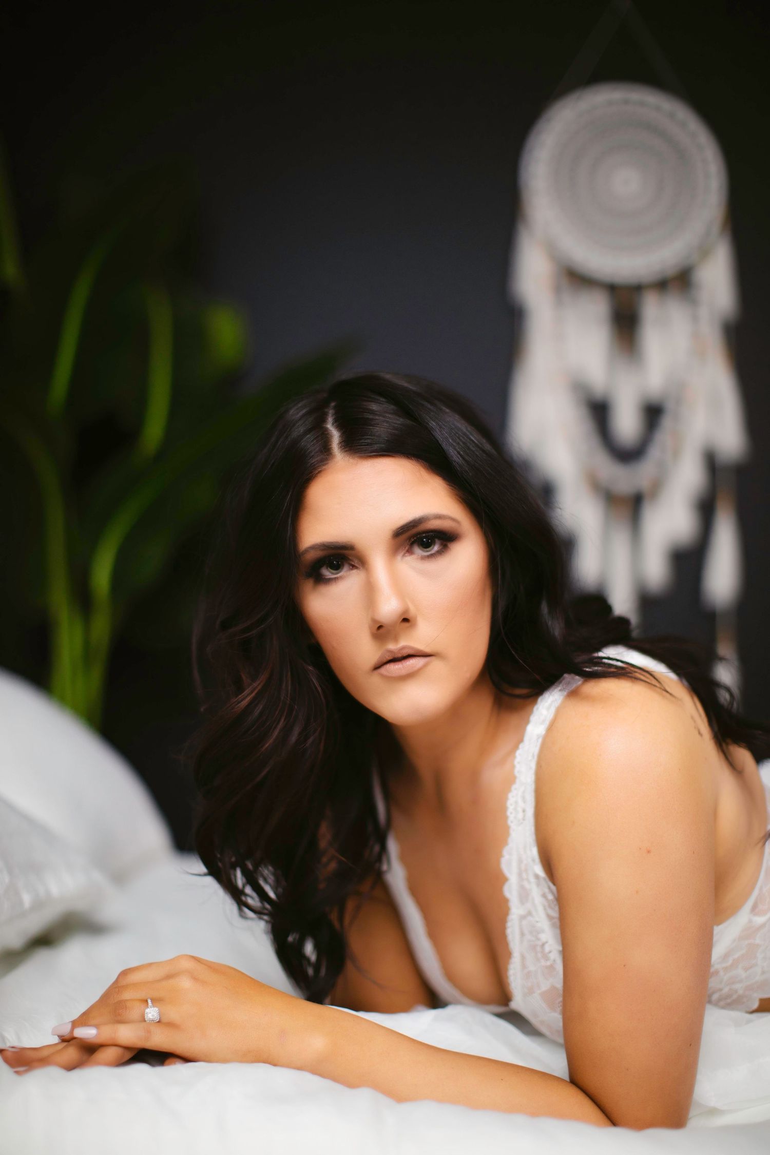 Boudoir photography session with white dreamcatcher in background and lace lingerie.