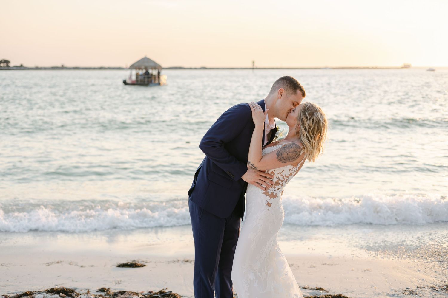 Bride and groom share their first kiss at their ocean front venue. Captured by local Bradenton photographers