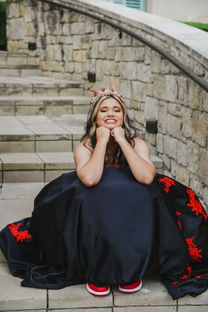 A flowing black dress with red accents photographed on stone steps.