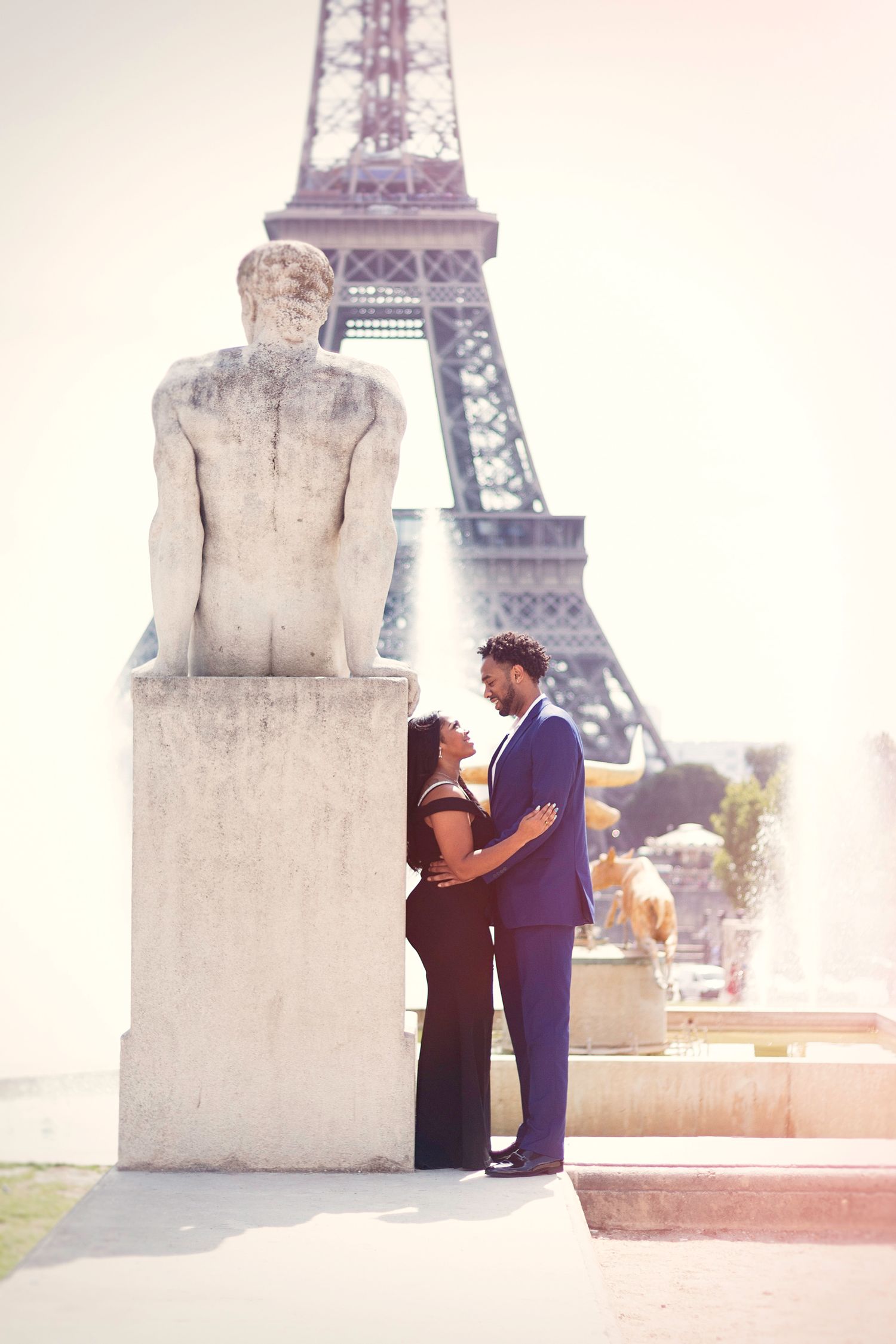 A romantic couple enjoying their time together in Paris, posing in front of the Eiffel Tower