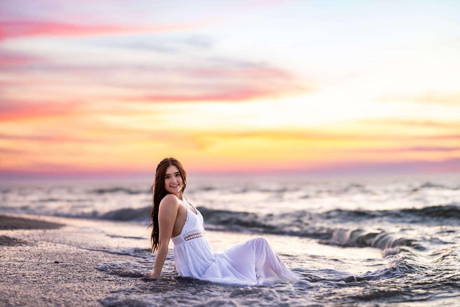 Sunset beach scene with soft pastel sky colors over ocean waves.