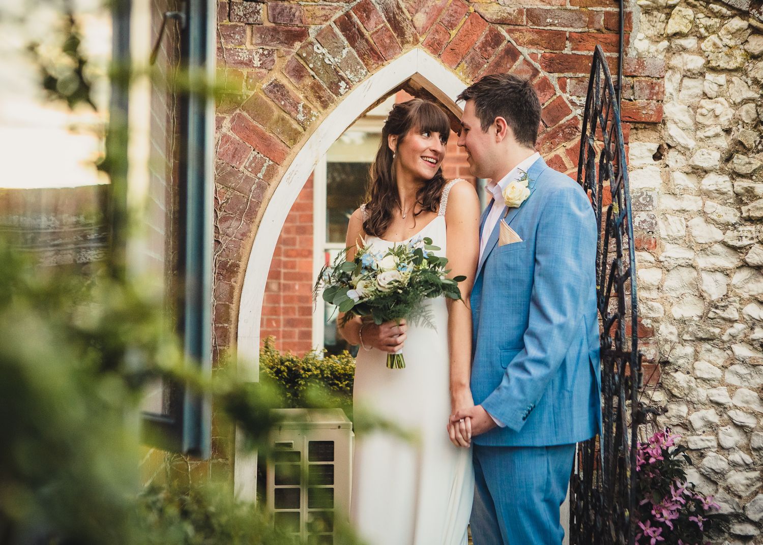 bride and groom in archway at titchwell manor