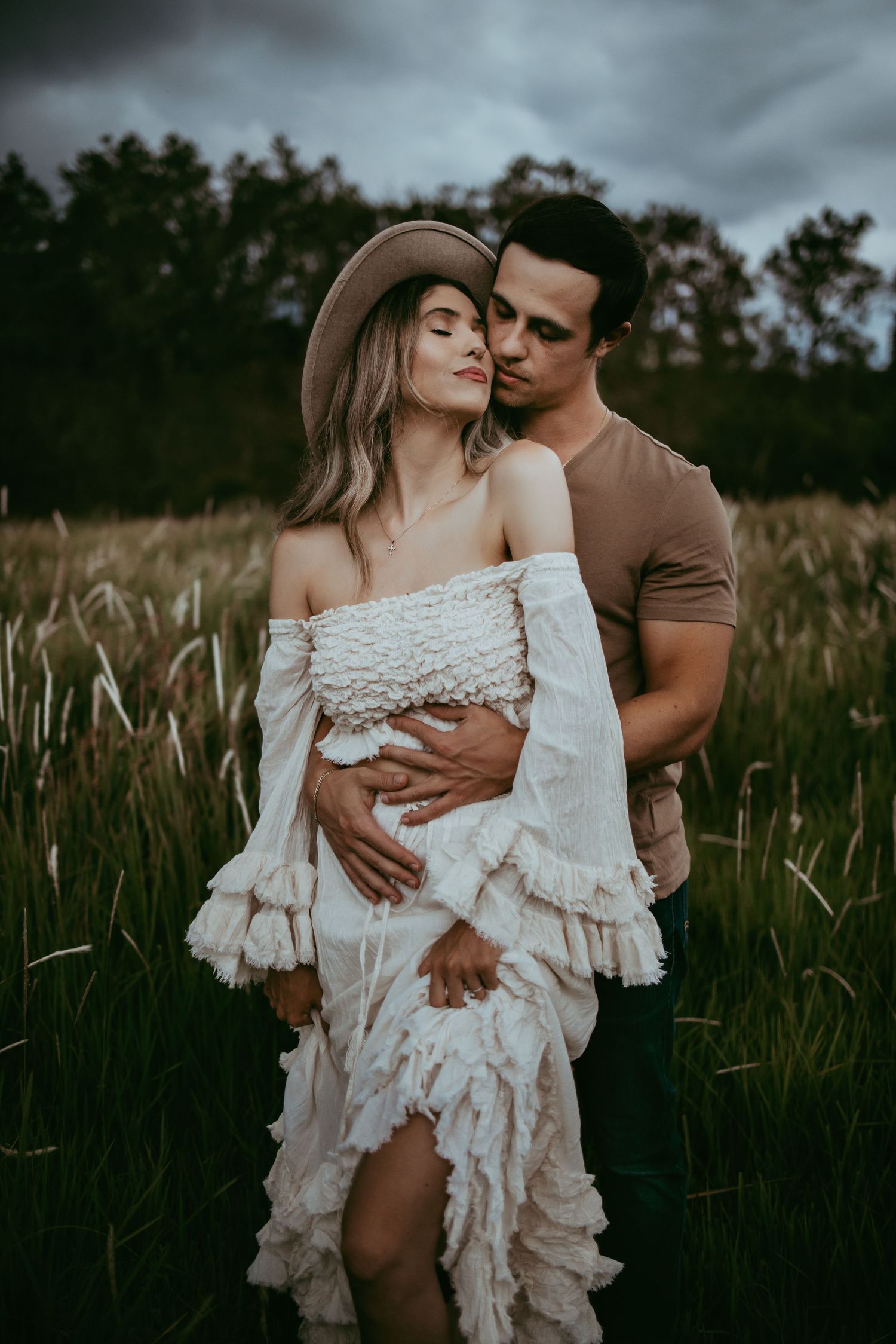 Lakeland family photographer- couple cuddling in field