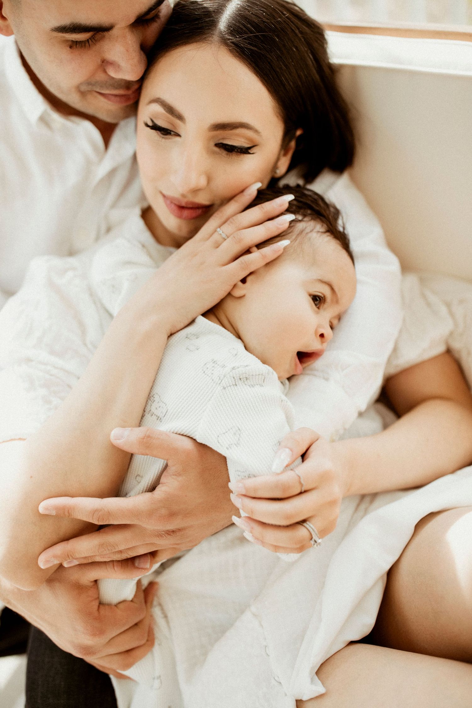 Intimate family moment captured in soft natural light indoors.