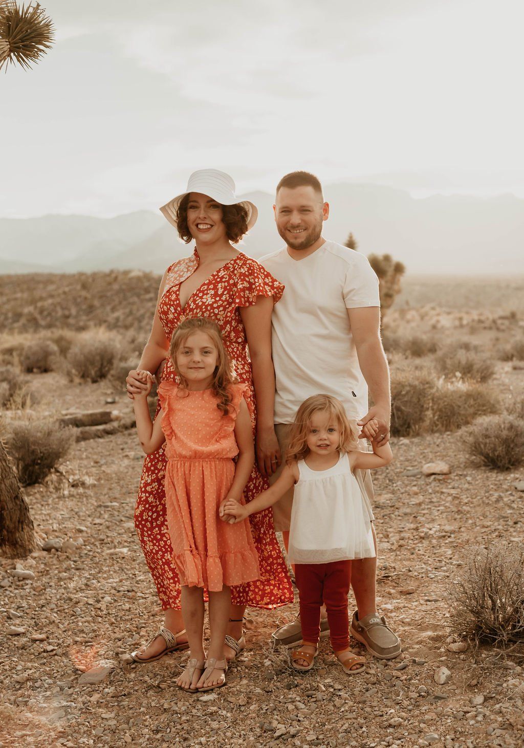 ALT= " LAS VEGAS BASED MATERNITY PHOTOGRAPHER SHOOTS COUPLES IN THE DESERT WITH MOUNTAINS WEARING WARM COLOR OUTFITS"