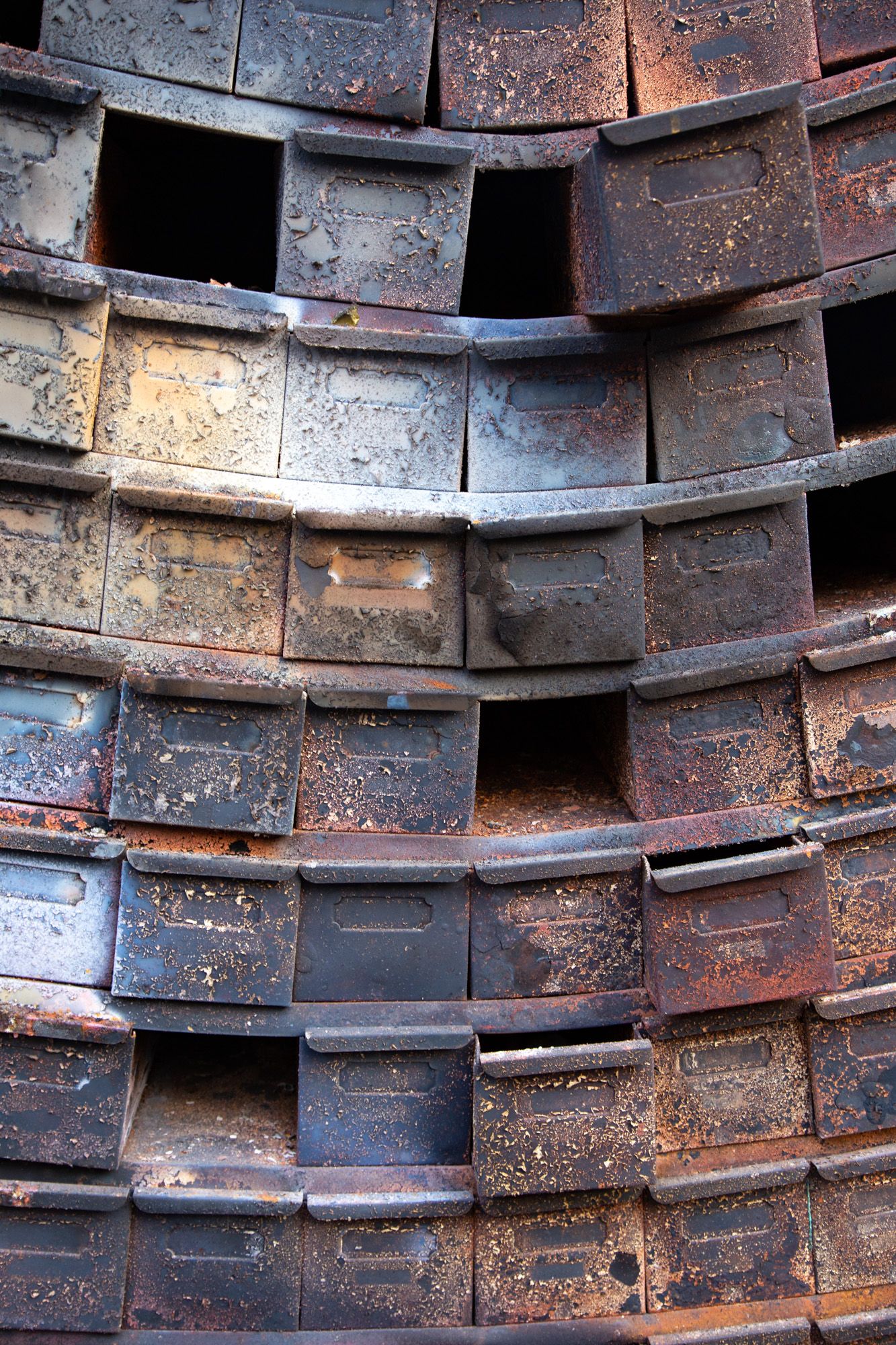 Close-up of weathered industrial brick structure with geometric pattern of empty compartments.
