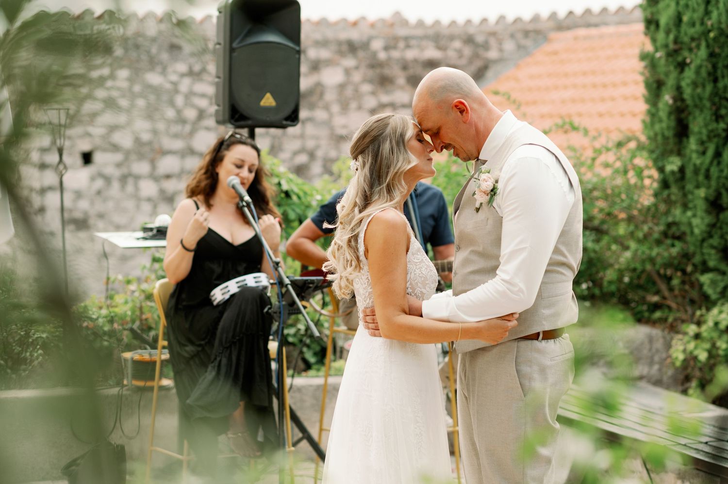 Wedding celebration in a garden setting with musicians performing nearby.