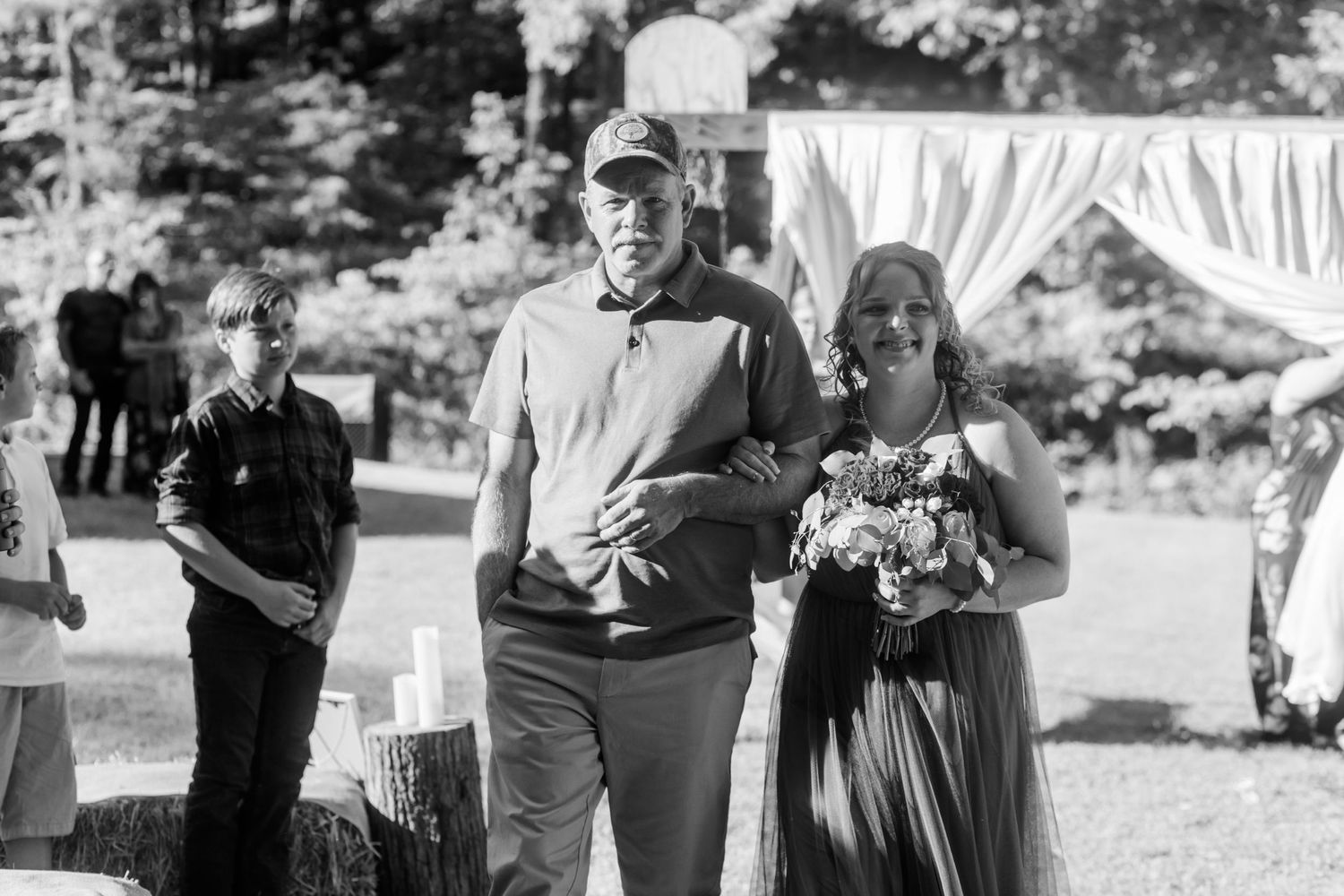 Black and white candid shots of wedding guests during an outdoor ceremony.