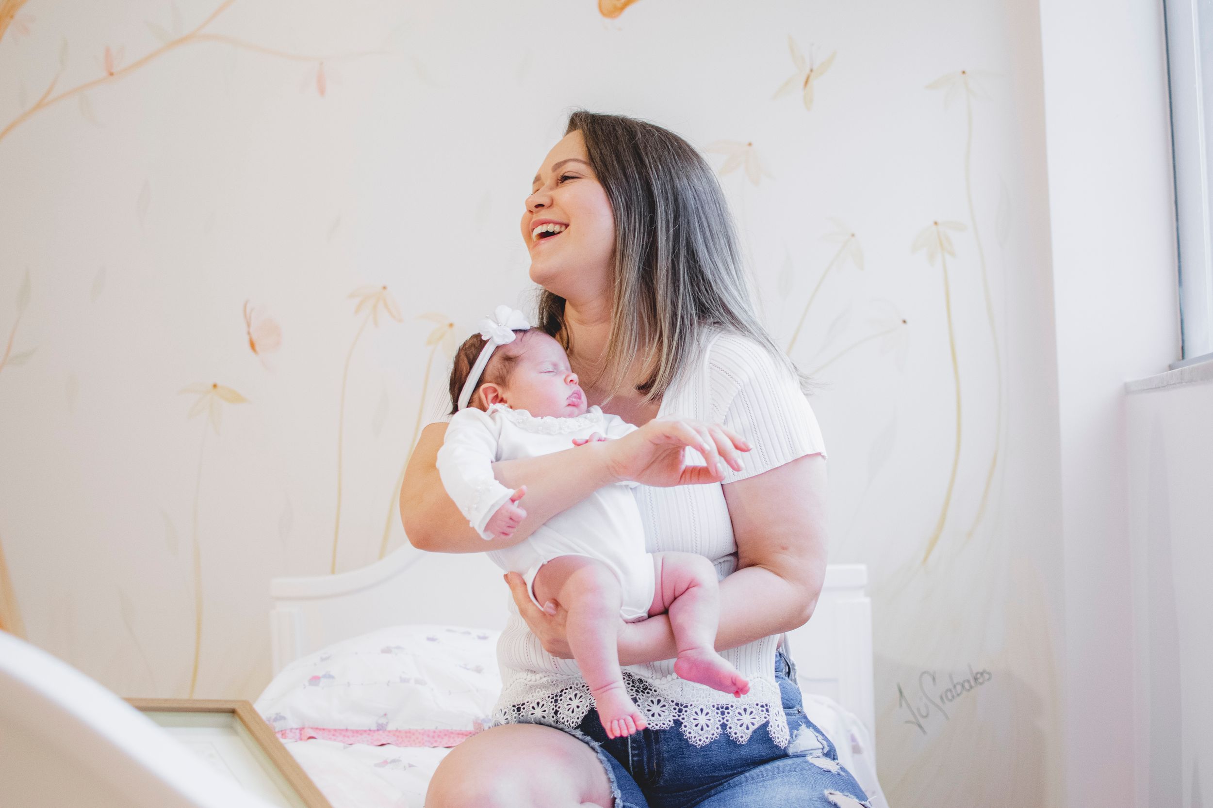 A tender bonding moment showing comfort and care between parent and infant in a bright room.