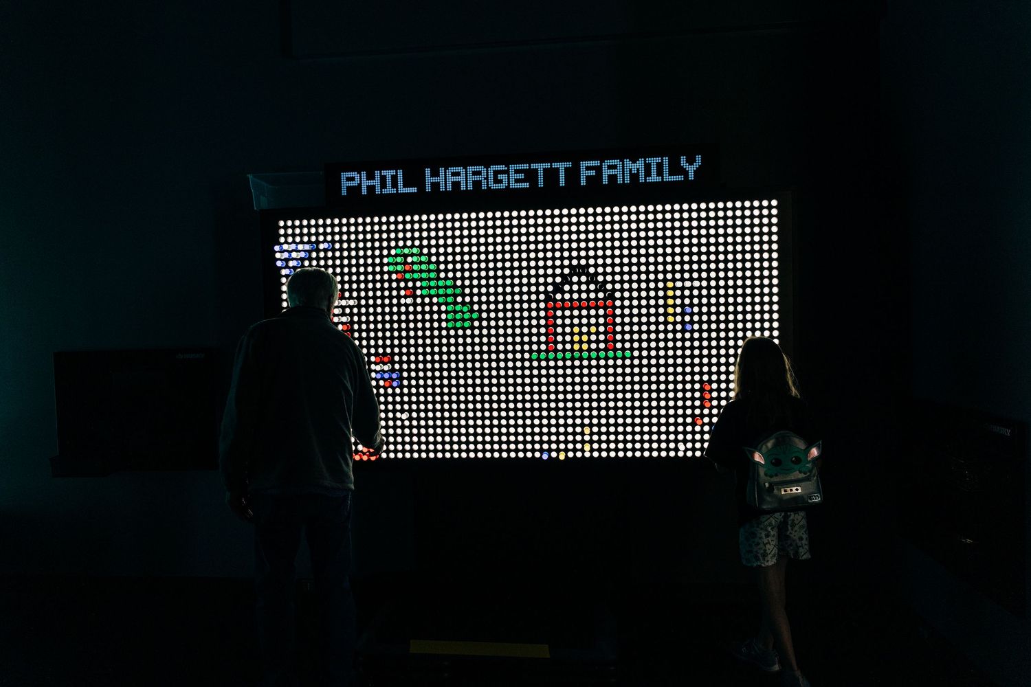 man and girl play with large light bright game at Monroe Science Center