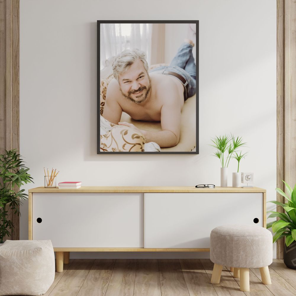 Black framed boudoir photo displayed above a modern white sideboard with decorative plants.