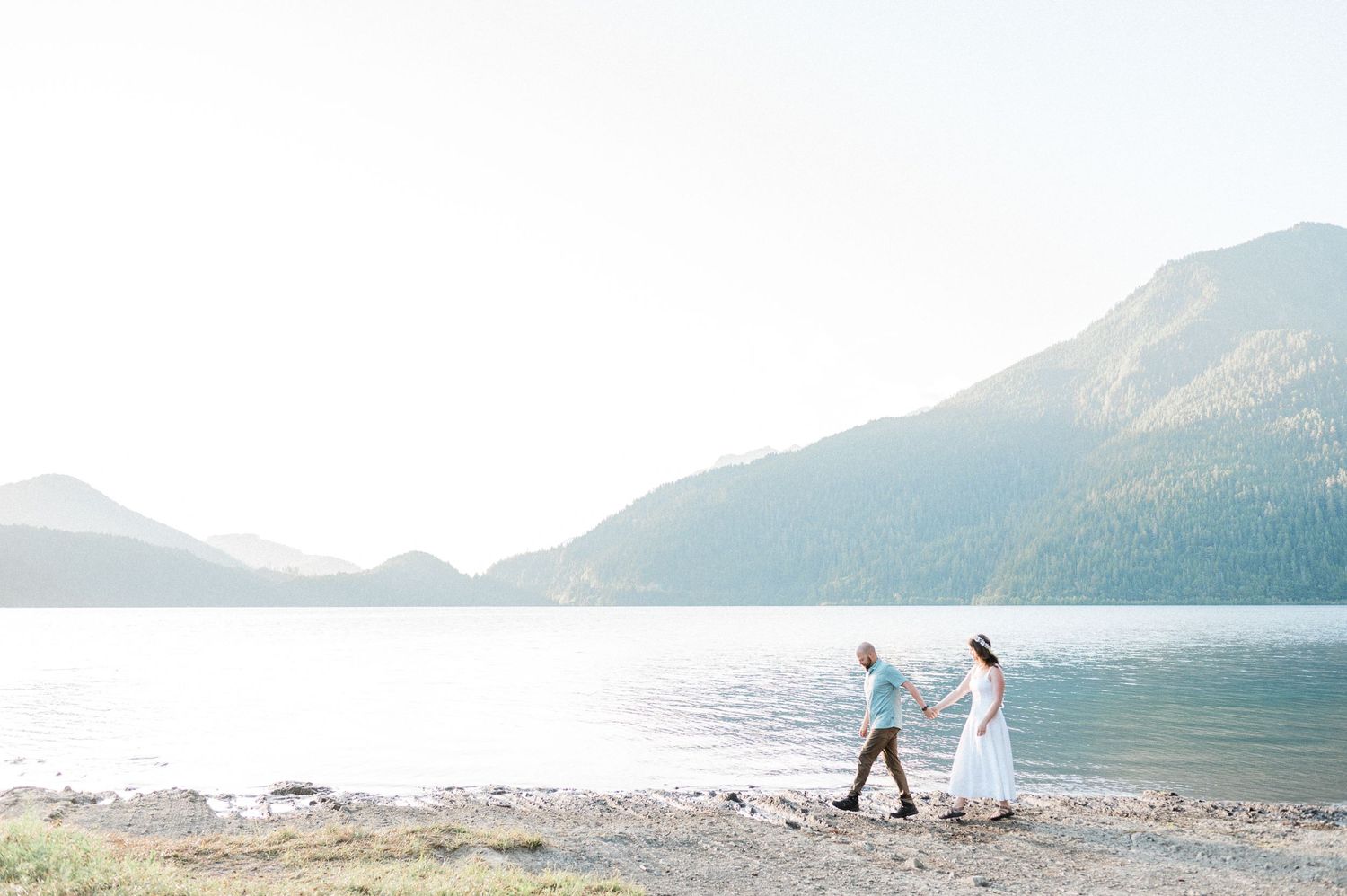 groom leads his bride on a walk on the shores of Lake Crescent. Photo by Tori Shults.