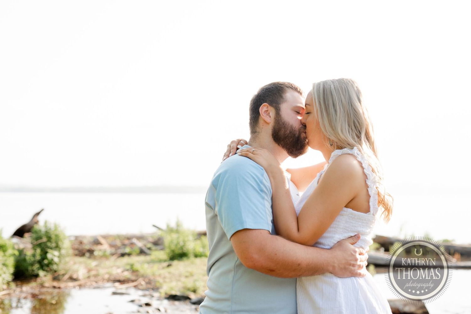 An intimate embrace captured against a bright, airy waterfront backdrop.