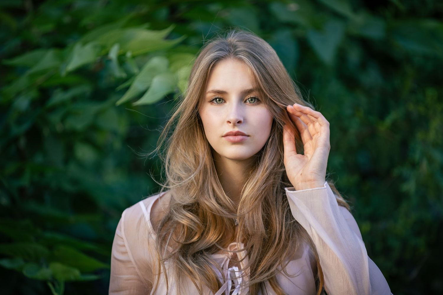 Portrait of woman with long brown hair in natural outdoor setting.