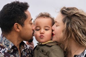 Close up of mom and dad kissing their baby son on the cheeks - shot by Milwaukee family photographer Rachel Dickman.