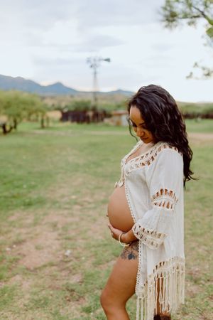 White crochet shawl flows in the breeze against a mountain landscape.