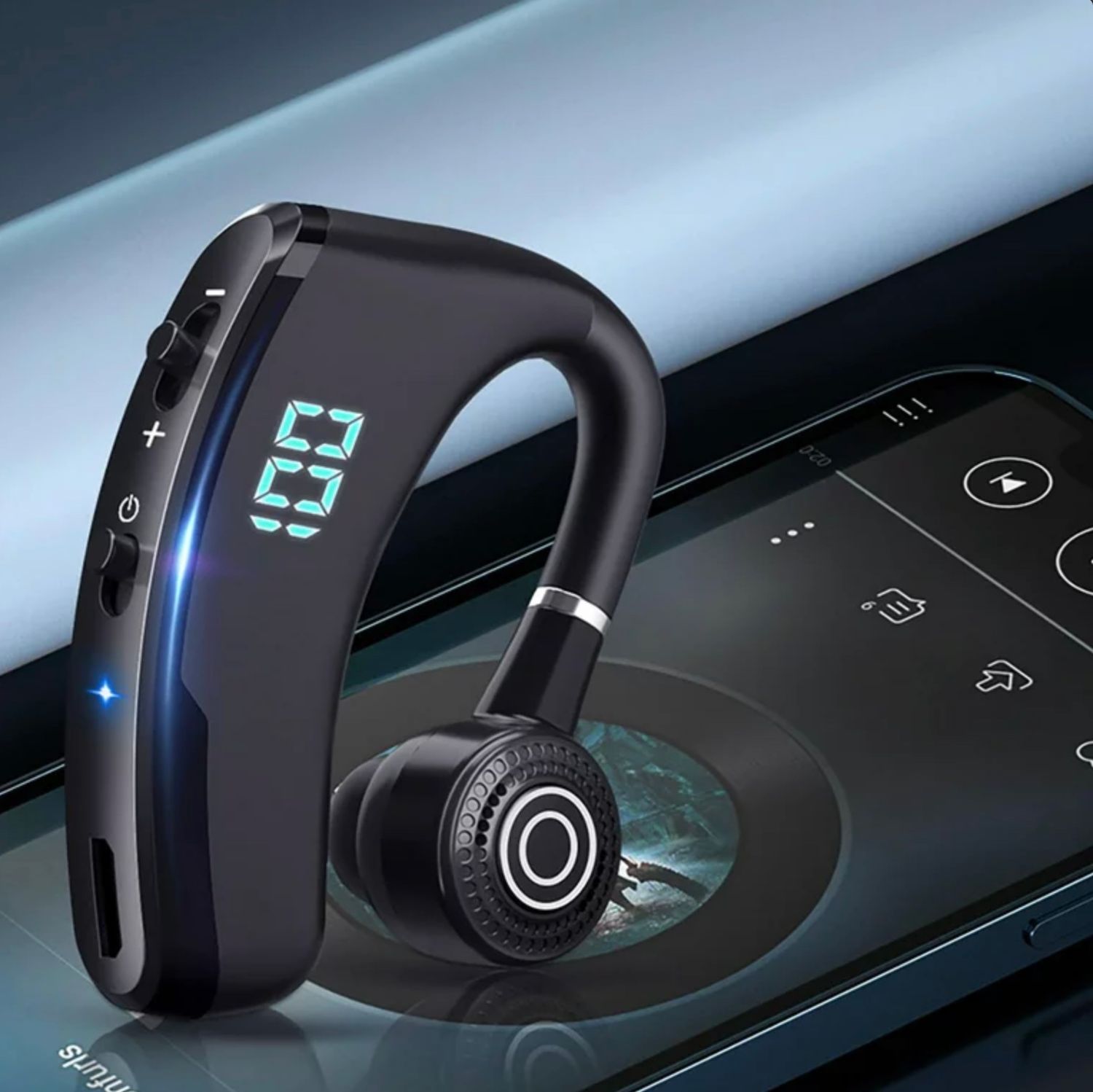 Bluetooth earpiece with LED display showing battery percentage on phone surface.