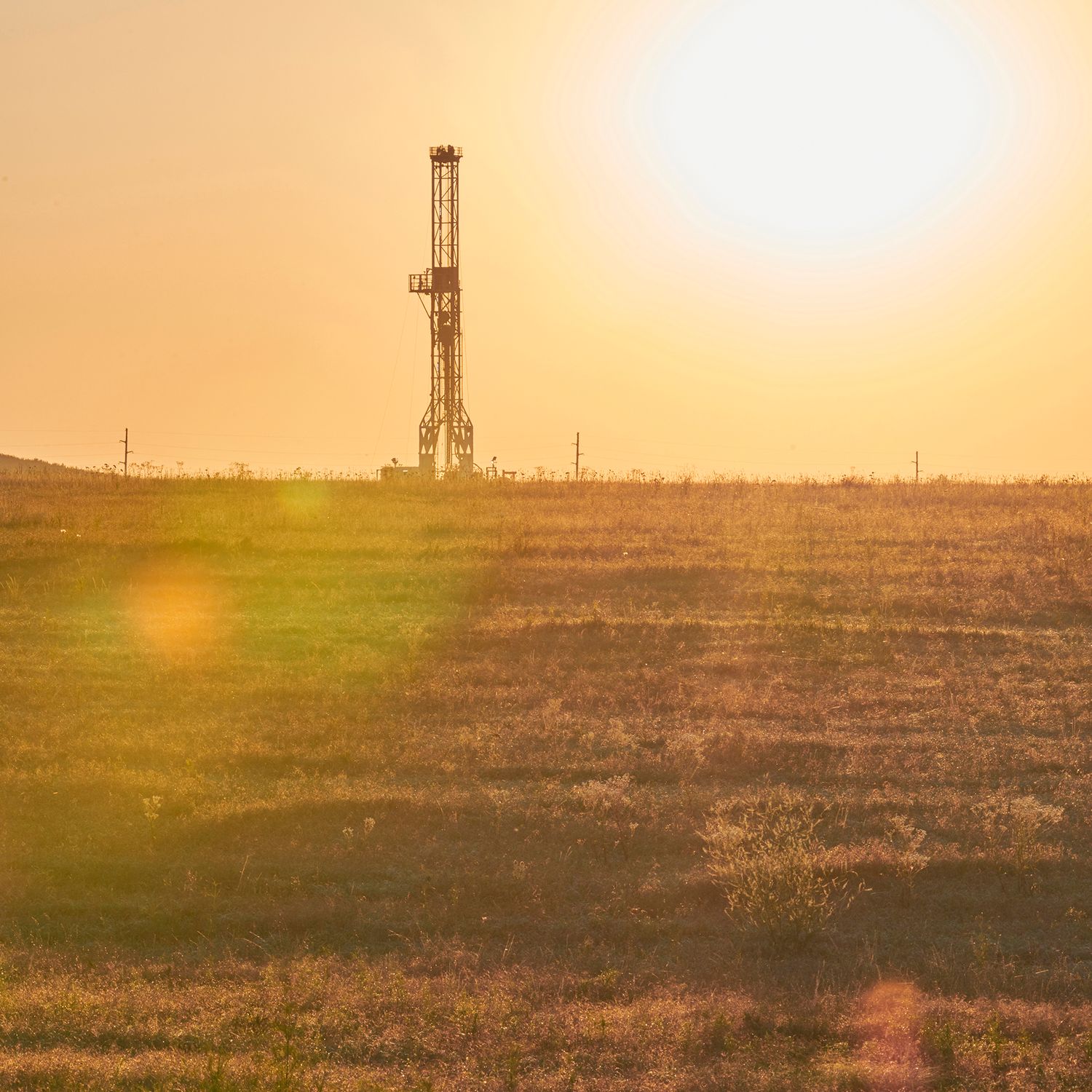 Drilling rig at sunset with yellow sky